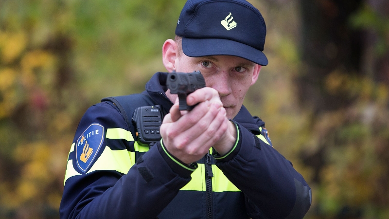 agent richt bij oefening zijn dienstwapen