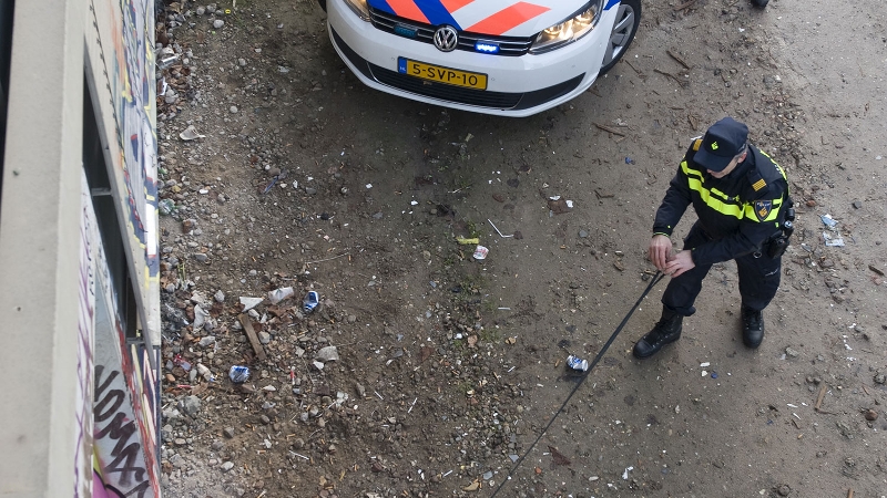 agent naast auto van bovenaf gezien