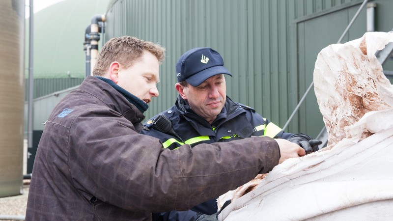 agenten houden een milieucontrole op een bedrijfsterrein