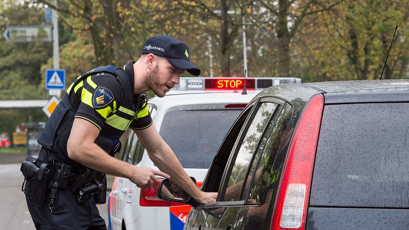 agent spreekt automobilist bij verkeerscontrole